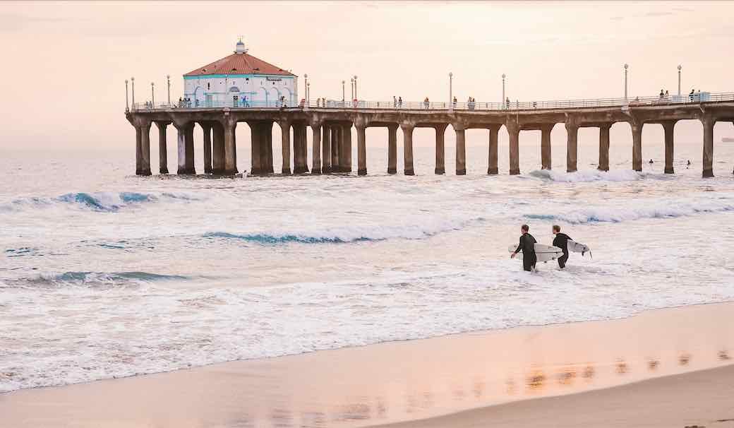 two-surfers-entering-water-by-manhattan-beach-pier